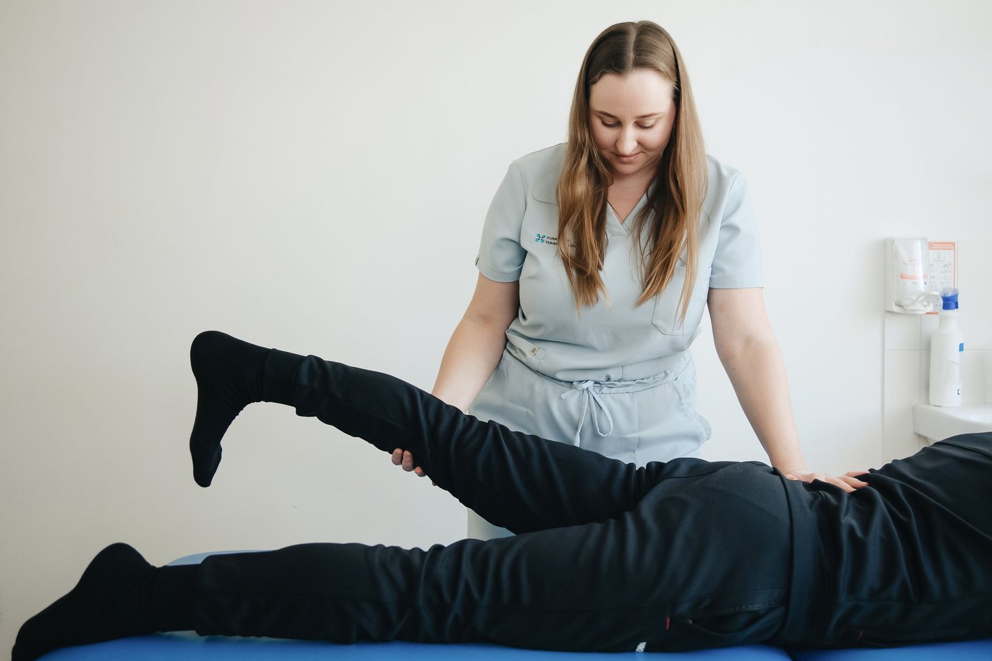 A rehabilitation professional assisting a patient during therapy